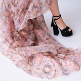 Close-up of the Ode to Jove Twilight Reverie Ball Gown's flowing organza train and baroque print, paired with black platform heels.