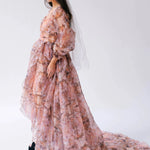Side profile a woman wearing the Ode to Jove Twilight Reverie Ball Gown with long sleeves and flowing silhouette, styled with a tiara and veil.