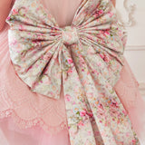 Floral-patterned Grand Bow Sash in Rosewater Pink Print attached to a pink garment