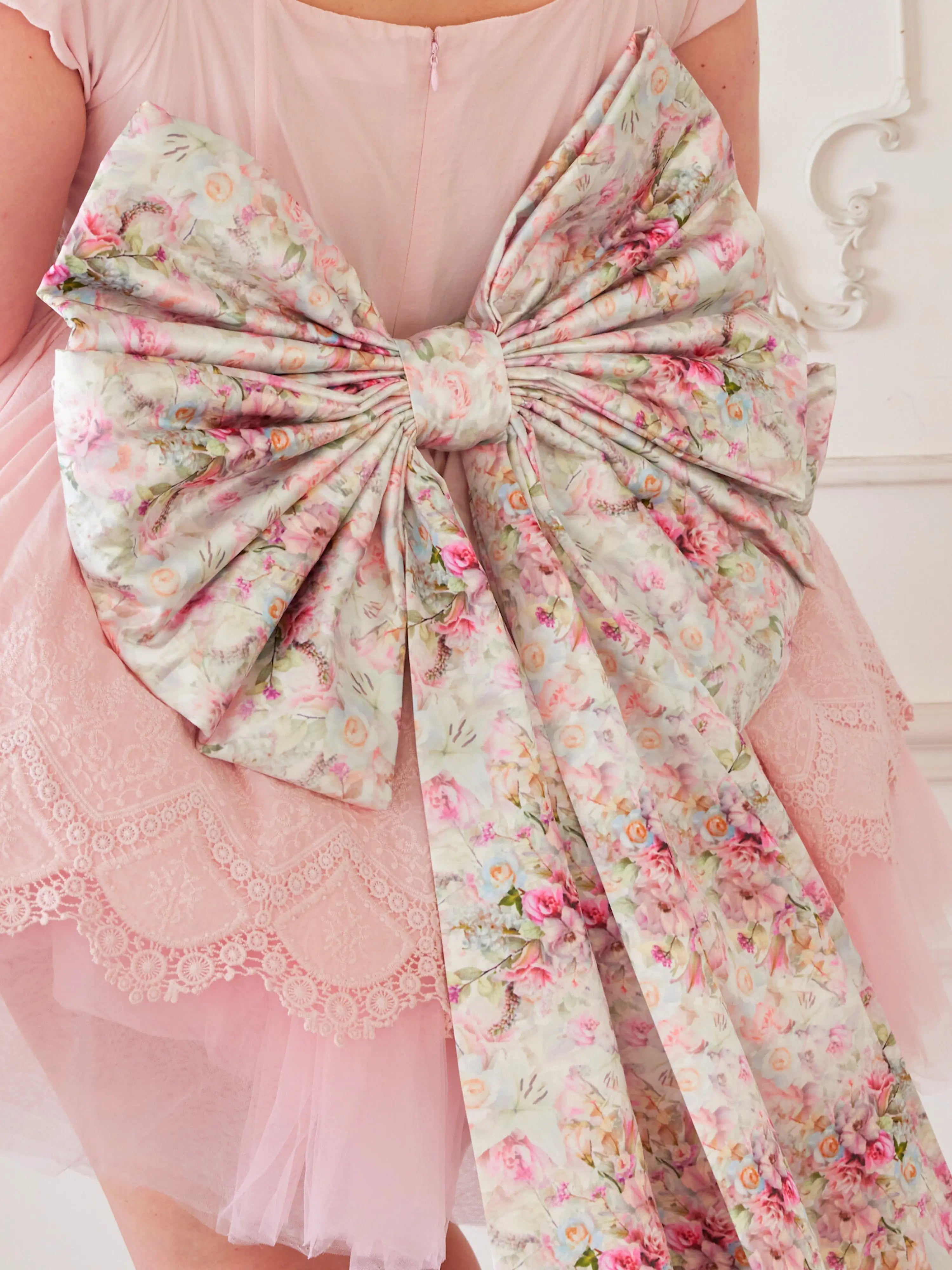 Floral-patterned Grand Bow Sash in Rosewater Pink Print attached to a pink garment