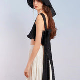 Woman in a black hat and white dress showcasing the Sand Castles Bow Blouse Top