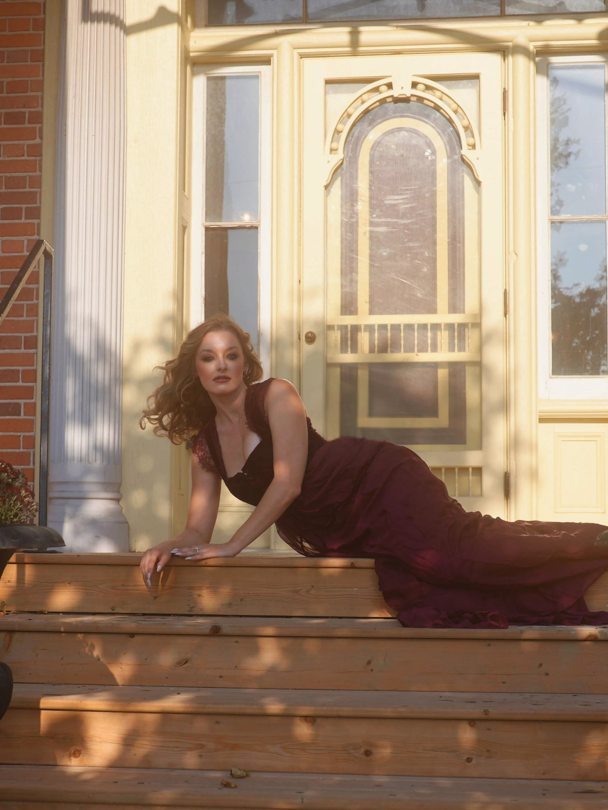 A woman wearing a red velvet bodice corset dress named the scarlet red scorned lovers gown.