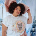The Baby Antoinette Silk Hair Bow paired with a graphic cat tee and floral skirt, showcasing its dramatic oversized pink silhouette.
