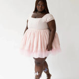 Woman in a Soft Pink Blossom Dress with short sleeves and silver strappy sandals