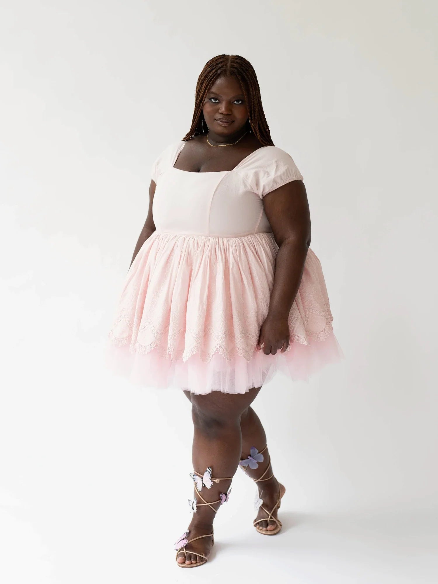 Woman in a Soft Pink Blossom Dress with short sleeves and silver strappy sandals