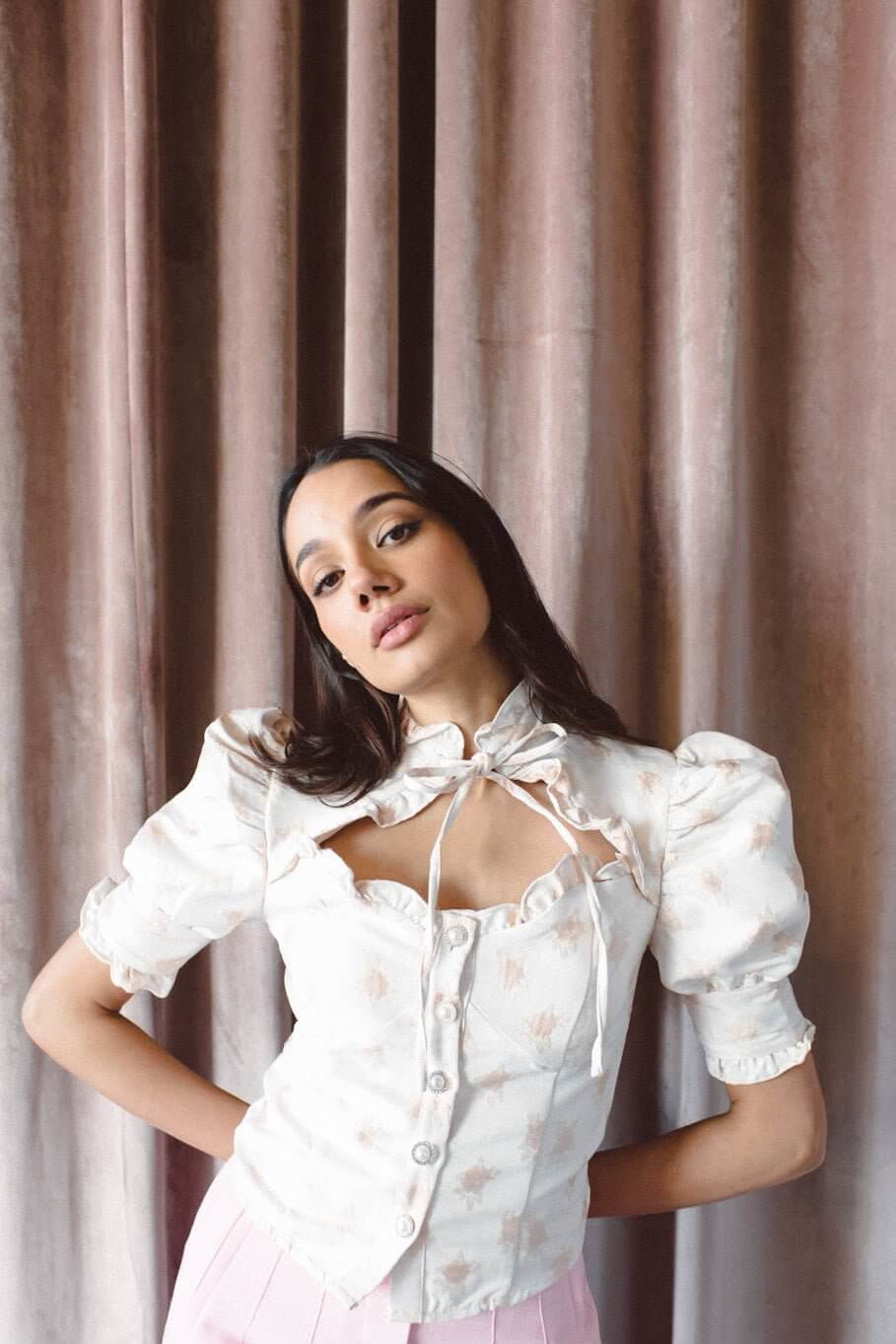 Woman in a white puff-sleeved top with a bow, showcasing Syrup Bloom Jacquard design