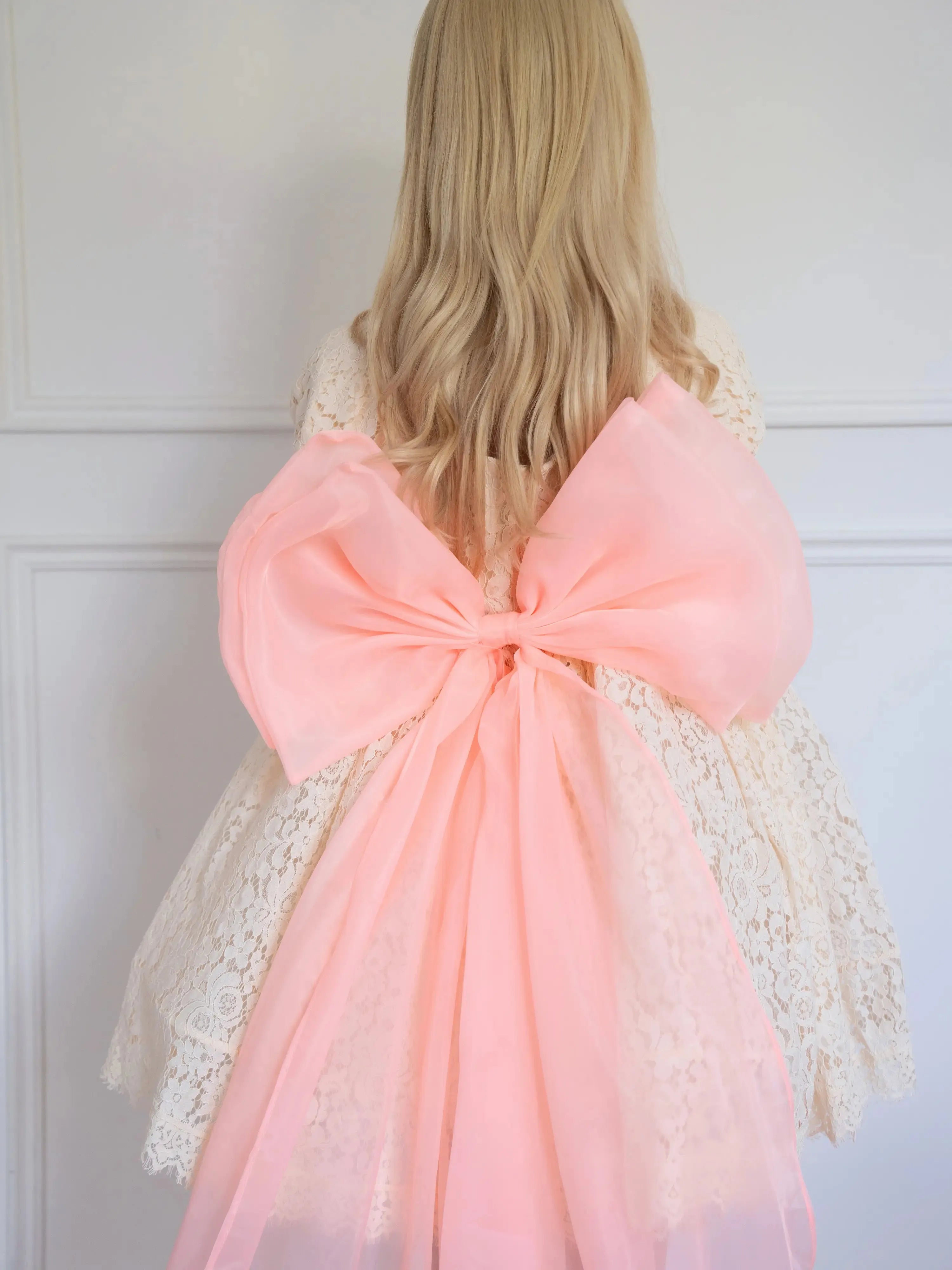 Tastes Like Peaches Grand Bow Belt in electric peach organza, styled on a lace dress with oversized bow and flowing sheer tails.