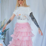 The Little Lamb Tee styled with a pink ruffled skirt, ideal for lovers of soft, romantic cottagecore fashion and whimsical prints.
