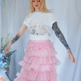 The Little Lamb Tee styled with a pink ruffled skirt, ideal for lovers of soft, romantic cottagecore fashion and whimsical prints.