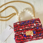 Front view of The Little Lady Tweed Mini Purse featuring textured tweed fabric, pearl top handle, and detachable gold chain for elegant wear.