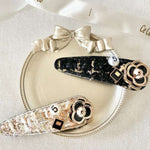 Two decorative peony hair clips featuring floral designs and rhinestone accents.