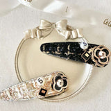 Two decorative peony hair clips featuring floral designs and rhinestone accents.