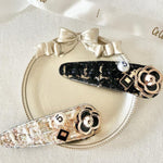 Two decorative hair clips featuring floral designs and rhinestone accents for the Tweed Peony Hair Clip