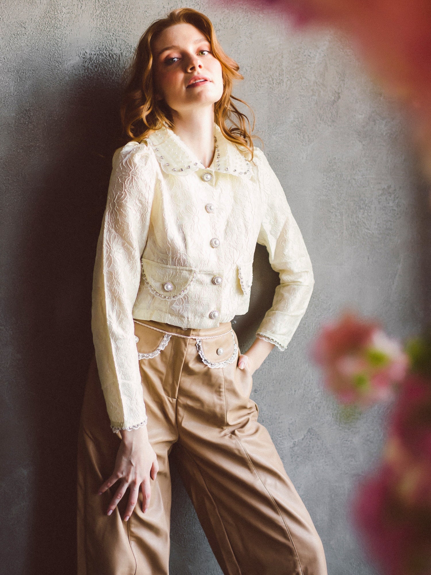 Woman in a white buttoned jacket and beige Valentina Faux Leather Trousers