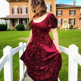 Woman in a burgundy velvet viola dress with short sleeves, showcasing elegance and style