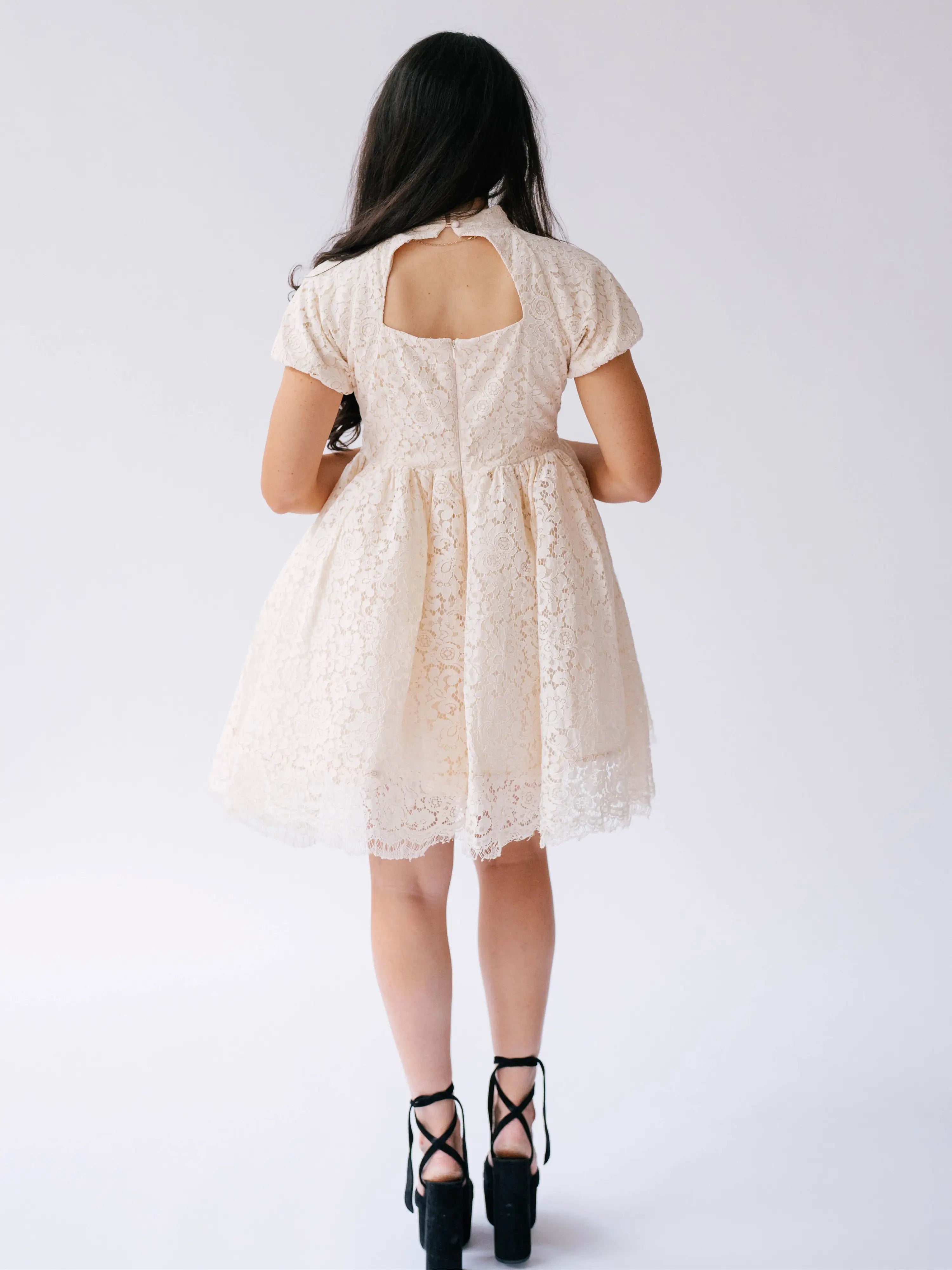 White lace mini dress with puff sleeves and a knee-length tulle skirt.