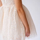 Delicate white lace mini dress with short sleeves and a flared skirt.