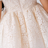 Elegant white lace mini dress with a full skirt and floral pattern. Perfect for weddings.