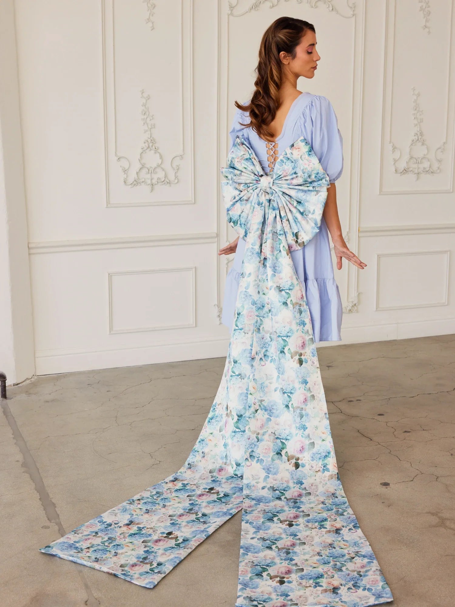 Elegant floral print gown featuring a grand bow sash and graceful train