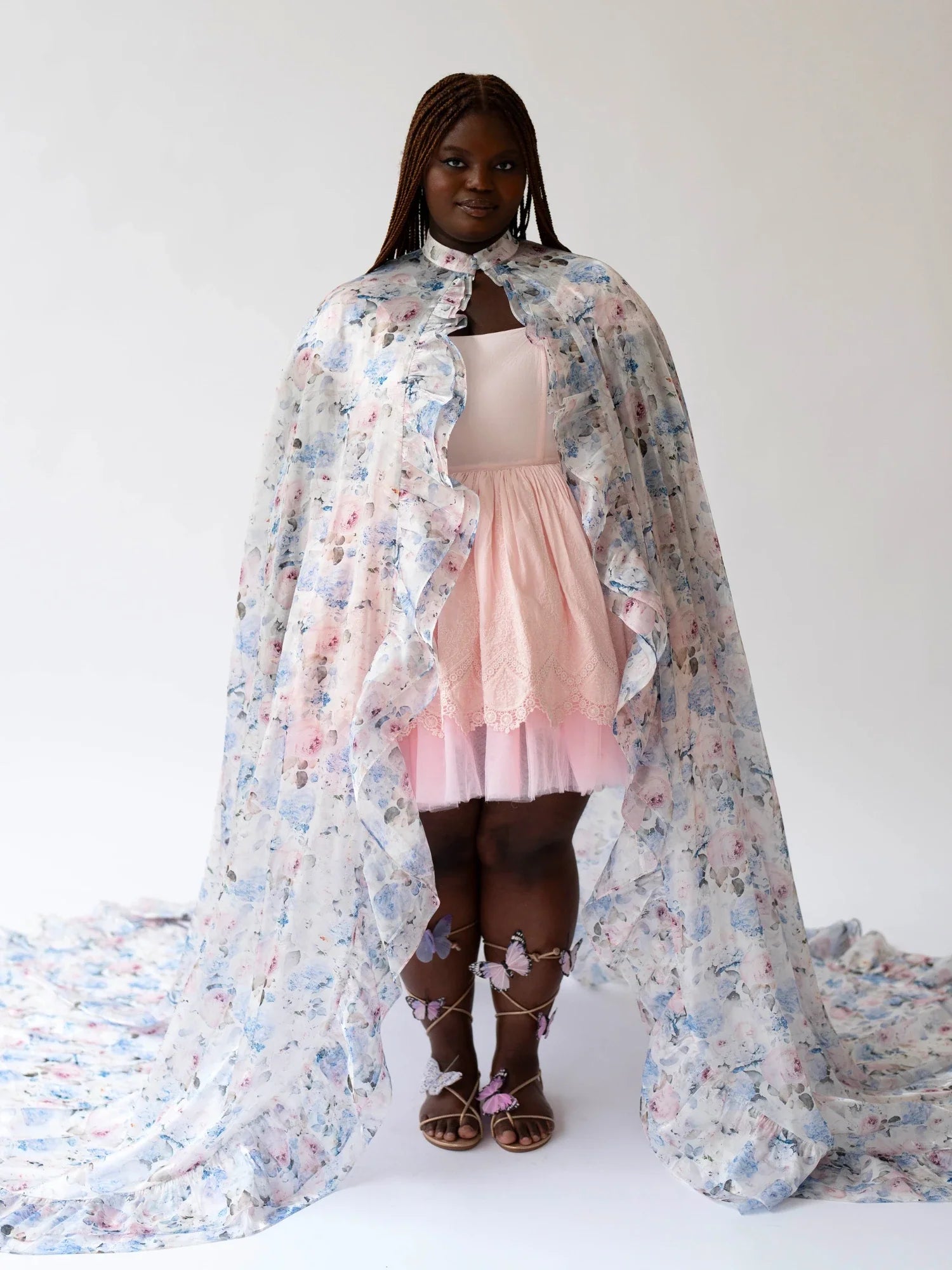 Young girl in a pink dress and floral cape featuring the Wild Bloom Priestess design