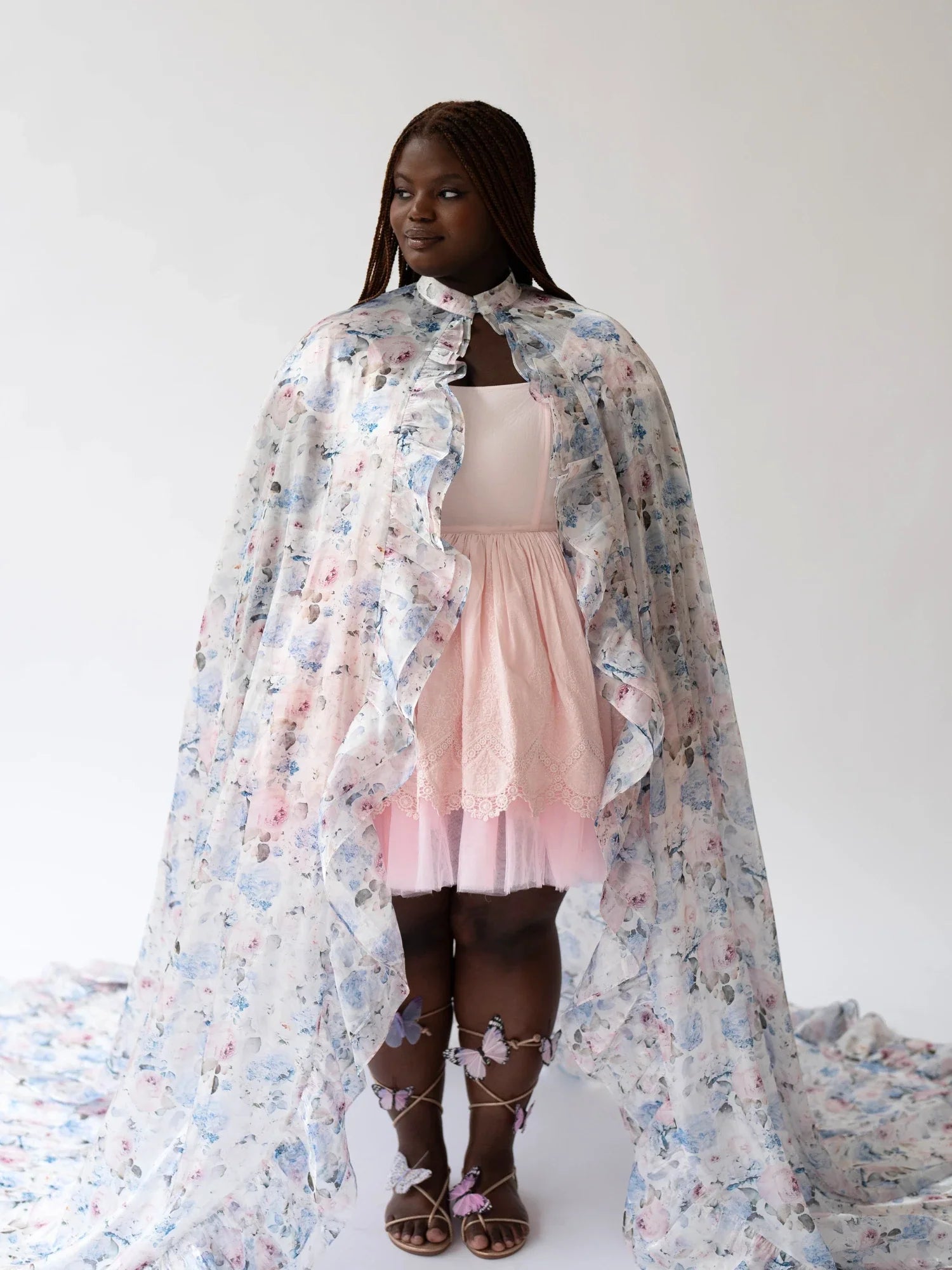 Young girl in pink dress wearing the Wild Bloom Priestess Cape with floral patterns